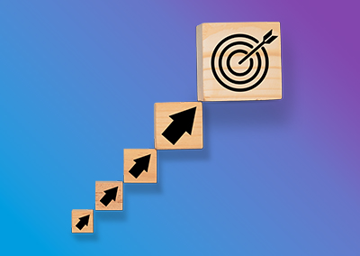 Four wooden blocks with arrows that point to a fifth wooden block with an image of a target.